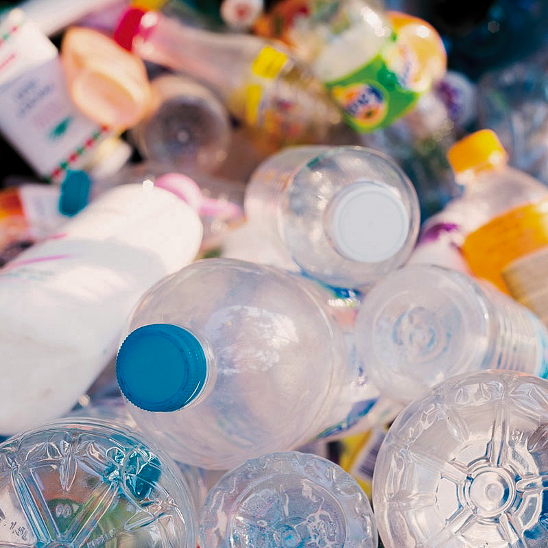 Photo shows a stack of used plastic bottles.