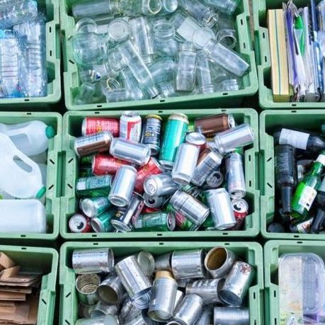 Photo shows a stack of used cans and plastic bottles